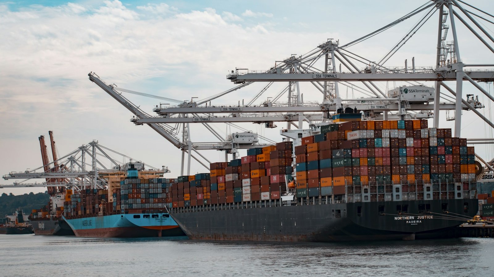 Stacks of colorful freight shipping containers loaded on a cargo ship at a port