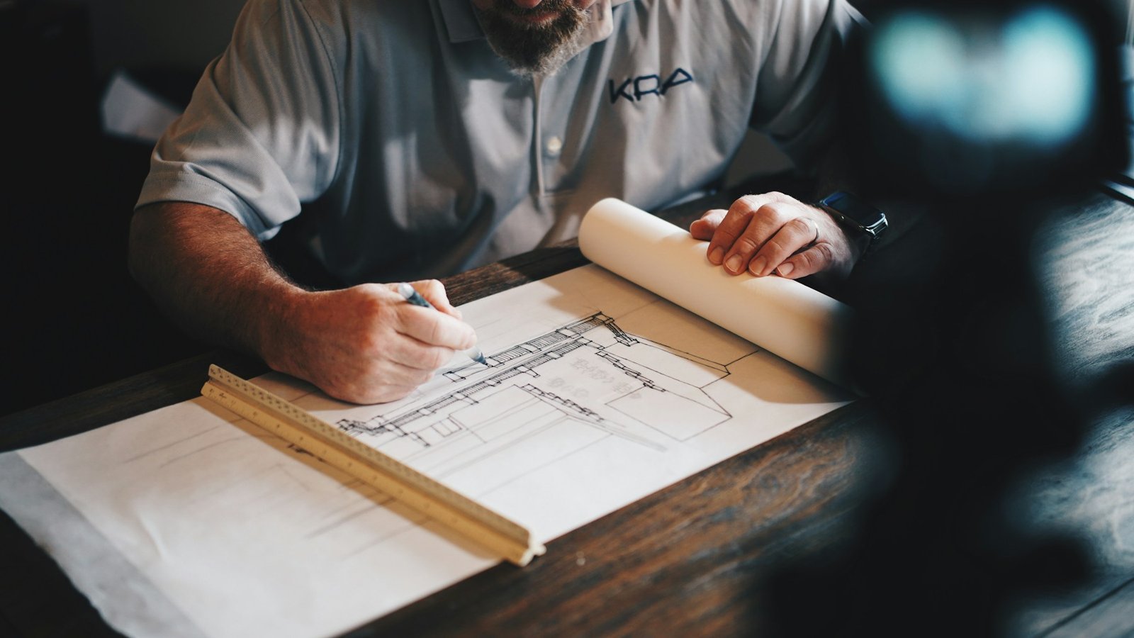 An architect working on a technical draft with a pencil and ruler